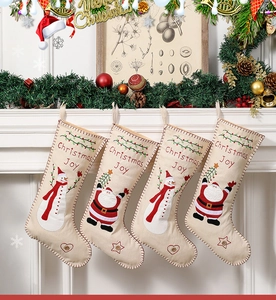 Detailed close-up of 4 embroidered Christmas stockings hanging on a festive mantelpiece