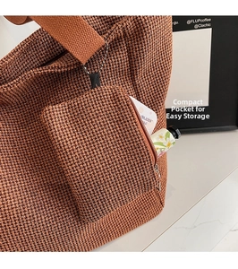 Detail of a brown woven tote bag showing its matching small zipper storage pouch.