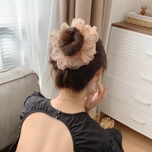 Chouchou élégant en résille à motif cœur brun sur un chignon de style coréen