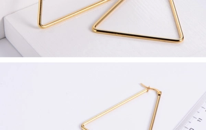 Detail view of large gold triangular hoop earrings with precise buckle and scale reference