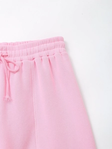 Detailed view of pink joggers featuring elastic waistband and matching drawstring ties