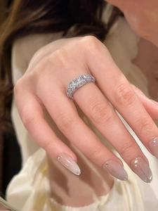 Detail eines silbernen Zirkonia-Rings mit funkelnden Steinen, getragen am Finger