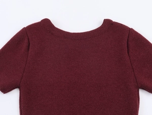 Close-up of wine red knit dress neckline and faux fur texture details on the shoulder