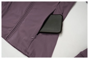 Detail showing invisible side zipper pocket on purple yoga jacket with smartphone inside