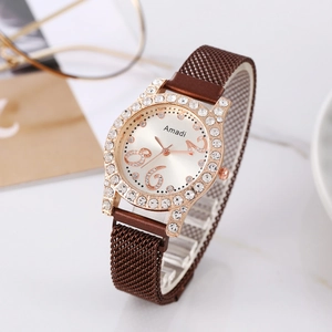 Detailed macro view of the rose gold rhinestone watch bezel and brown magnetic mesh strap