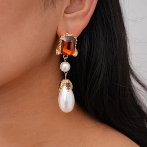 Detailed close-up of retro drop earrings featuring orange gemstone and waterdrop pearls