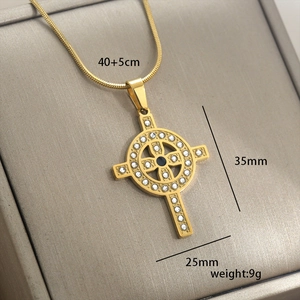 Vue détaillée du pendentif croix celtique dorée avec cristaux sur écrin gris