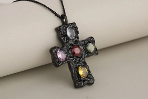 Close-up of gothic stainless steel cross pendant with colorful oval zircon gemstones