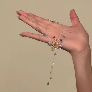 Close-up of a colorful handmade beaded floral pendant necklace on a transparent string