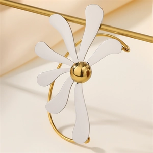 Detailed close-up of a two-tone gold and silver flower ear cuff on a gold metal stand