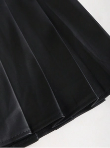 Detailed macro view of black PU leather pleats and fine stitching on a high-waisted skirt