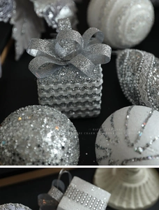 Close-up of silver glitter gift boxes and white sparkling baubles for Christmas decor