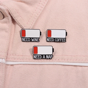 Detailed view of NEED WINE, COFFEE and NAP battery pins on pink denim fabric