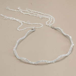Detail of silver wavy headband featuring elegant dangling crystal beaded tassels