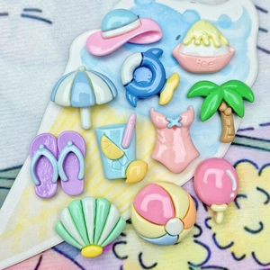 Flat lay of 11 summer beach resin charms including bikini and sunglasses for DIY crafts