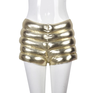 Detail of high-waist quilted gold metallic shorts with warm padding and glossy finish