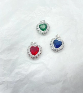 Macro detail of heart-shaped pendants with colorful zircons and silver micro-pave setting