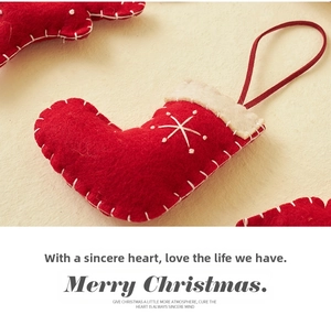 Detail of red handmade felt Christmas stocking ornament with white stitched star patterns