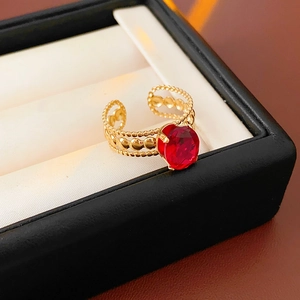 Macro shot of vintage gold open ring with large oval red gemstone and beaded detail