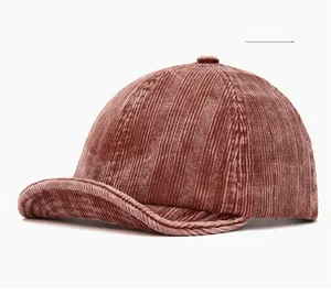 Detailed close-up of burgundy corduroy texture on a vintage short-brim baseball cap