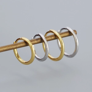 Detail showing polished gold and silver S925 sterling silver hoop earrings on a metal rod