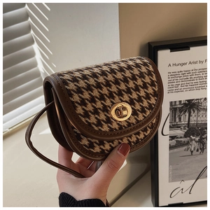 Detailansicht der braunen Mini-Satteltasche mit Hahnentrittmuster und Goldverschluss