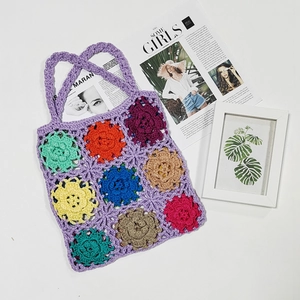 Handmade crochet tote bag with colorful floral patterns and purple knit texture
