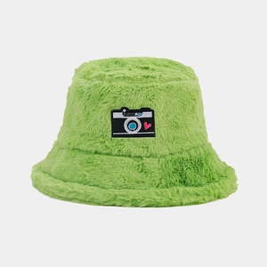 Close-up of bright green fuzzy bucket hat featuring a camera and heart embroidery patch