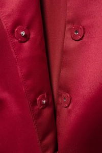 Close-up of hidden snap buttons on elegant red silk fabric of a Christmas suit