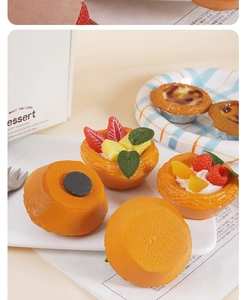 Detail of realistic fruit egg tart magnets with strawberry and mango on a white tray