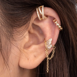 Detail of gold butterfly ear cuff set with pavé zircons and dangling tassel on ear