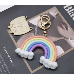 Macro detail of handmade five-color rainbow keychain with soft white pom pom clouds