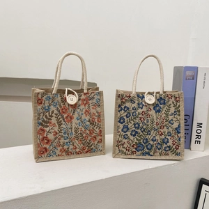 Detail view of linen tote bags with floral patterns, cotton rope handles and wood buttons