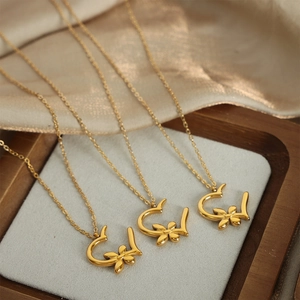 Three gold heart flower pendant necklaces made of titanium steel on silk fabric