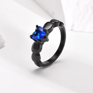 Detailed view of heart-cut blue gemstone set on a textured black stainless steel ring