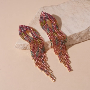 Close-up of luxury rhinestone tassel earrings with colorful gradient crystals on stone
