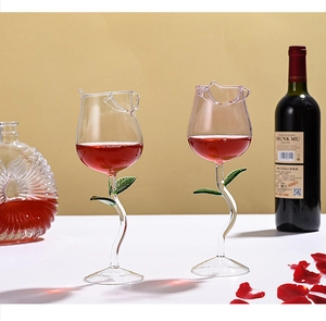 Detail of rose-shaped wine glasses with green leaf stems and petal-shaped rims