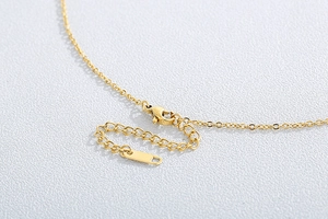 Detail of gold chain necklace featuring a lobster clasp and adjustable extender link