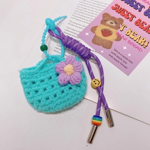 Porte-clés mini sac tricoté bleu avec fleur violette et perles colorées sur page
