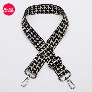 Detail of adjustable houndstooth bag strap with premium gunmetal metal swivel clasps