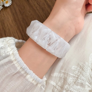 Detailed macro view of an ivory resin geometric bracelet with marble texture worn on wrist