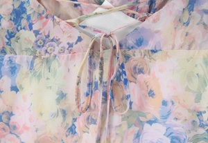 Close-up of floral chiffon dress detailing multi-color patterns and elegant front tie-up knot