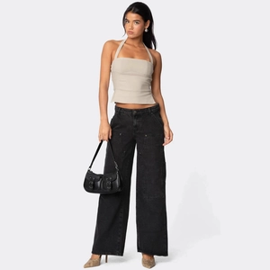 Haut licou beige pour femme avec jean noir à taille haute et jambes larges à rivets