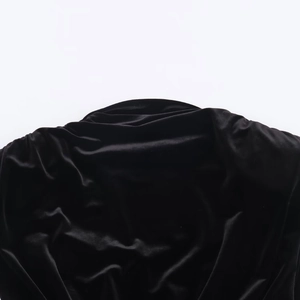 Detail shot of black velvet fabric texture and soft pleated folds of the mini dress