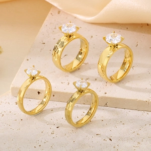 18K gold plated titanium rings with zircon stones on stone and silk background