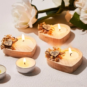Macro shot of heart-shaped wooden tea light holder set with dried flowers and thank you tags