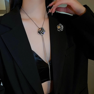 Detail of camellia zircon necklace with long tassel and sparkling black rose brooch