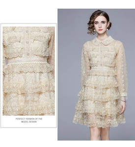 Détails de dentelle multicouche et col Claudine sur cette robe beige à volants