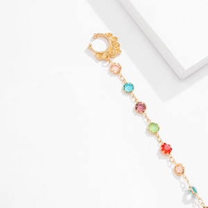Detail of a gold tassel chain ear clip featuring colorful crystals and faux pearls