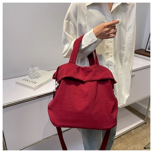 Detailed view of a large red nylon tote bag with wide straps for casual shoulder wear